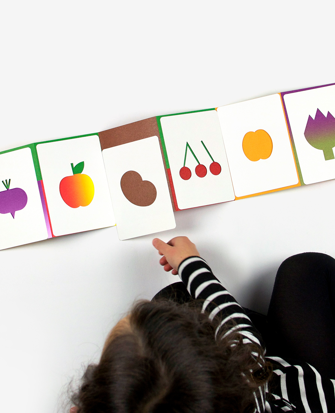 Child playing with the book-game Hello tomato